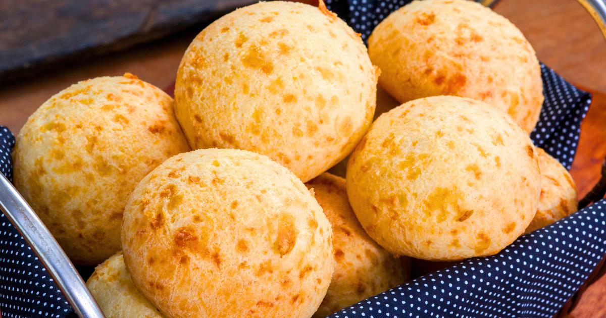 Bolinhas de pão de queijo douradas em uma assadeira.