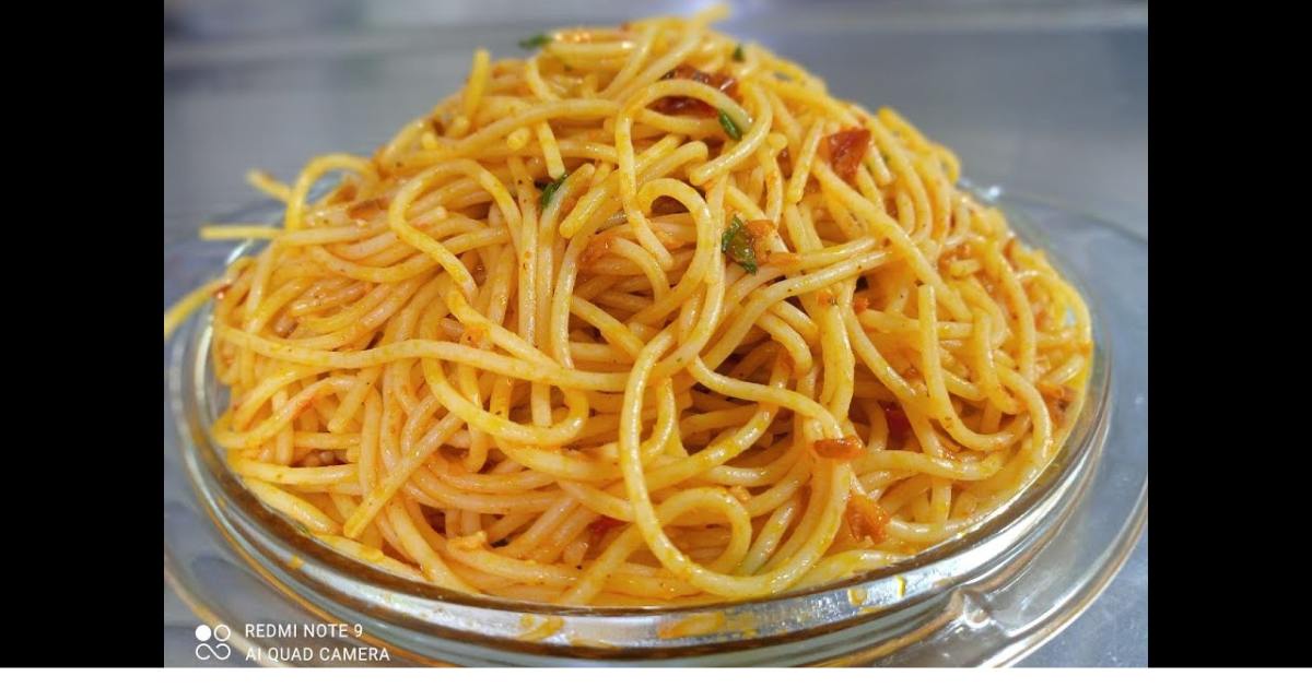 O macarrão com molho de tomate seco é um prato convidativo, com pedaços de tomate...