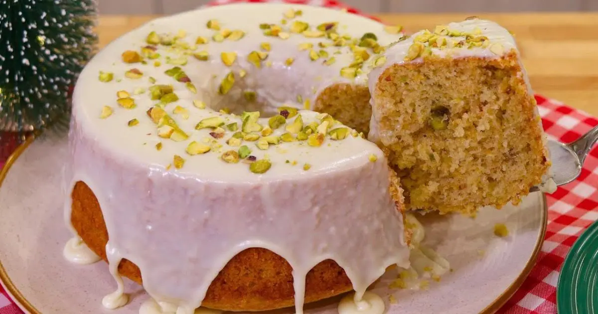 Bolo de laranja com especiarias, pistache crocante e cobertura cremosa, perfeito para ocasiões especiais....