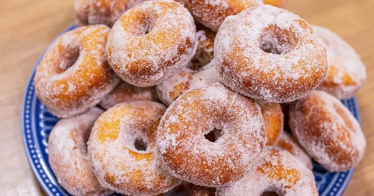 Donuts caseiros macios, fáceis, econômicos, fritos dourados e cobertos com açúcar refinado. Perfeitos para lanches!...