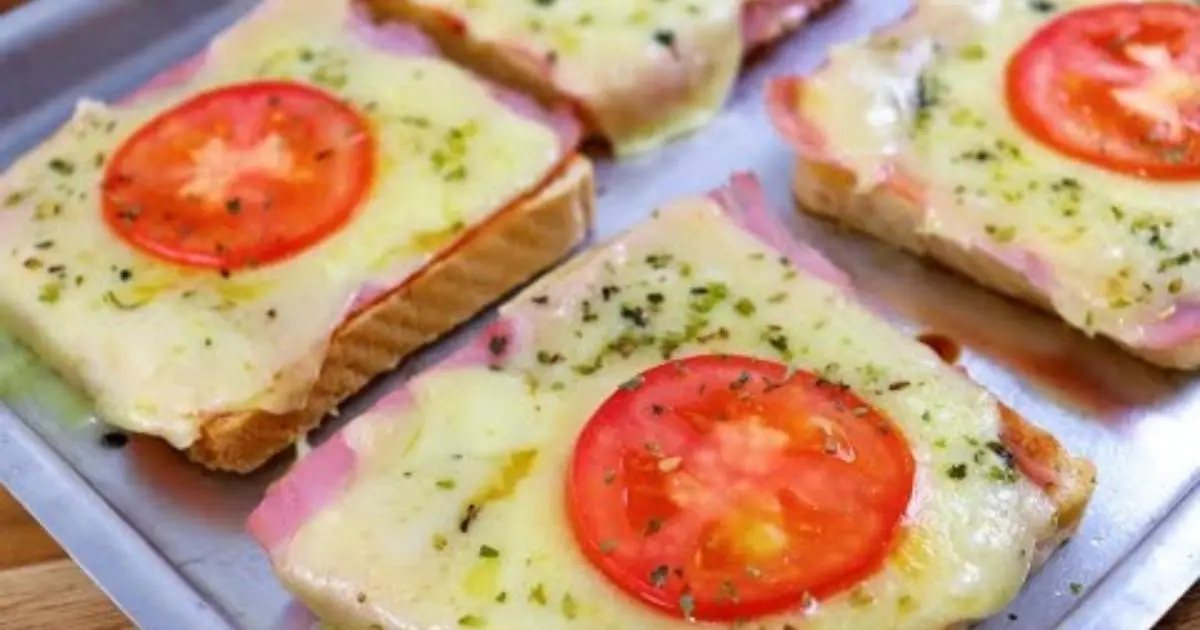 Mini pizzas práticas feitas com pão de forma, molho, presunto, mussarela e orégano....