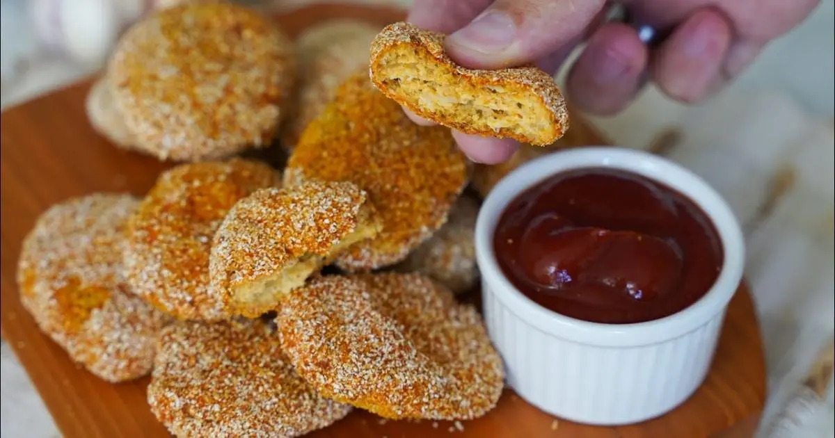 Nuggets caseiros saudáveis, assados ​​e crocantes, feitos com frango temperado....